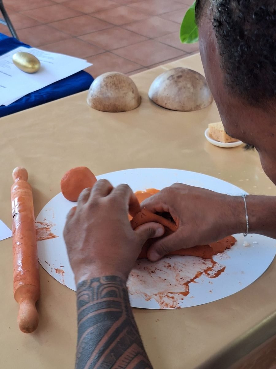 Un homme modèle l'argile au rouleau pendant un atelier Artpluriailes